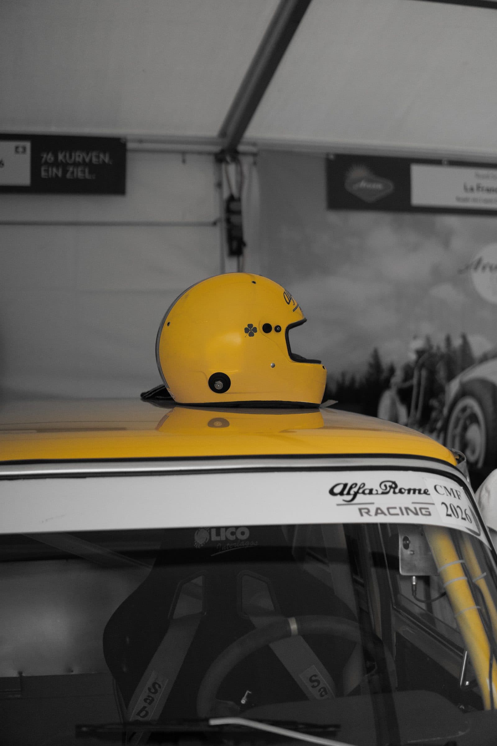 Gelber Rennhelm auf einem historischen Alfa Romeo